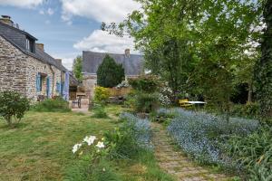 a garden with blue flowers in front of a building at Ville Moizo in Sérent