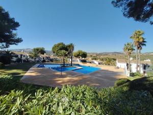 een zwembad in een tuin met palmbomen bij Casita Leo in Teulada