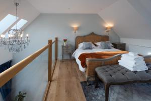 sypialnia z łóżkiem, krzesłem i żyrandolem w obiekcie Pigeon Cottage - Luxury country steading w mieście Perth