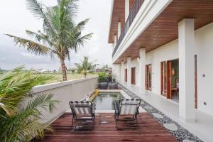 eine Terrasse mit Stühlen und einem Pool in einem Haus in der Unterkunft Kerti Suite in Munggu