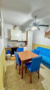 een woonkamer met een houten tafel en blauwe stoelen bij Suite De San Cristoforo N1 in Catania