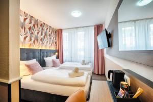 ドルトムントにあるHome Hotelのベッド2台とテレビが備わるホテルルームです。