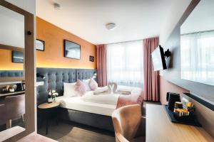 Habitación de hotel con cama y TV en Home Hotel, en Dortmund