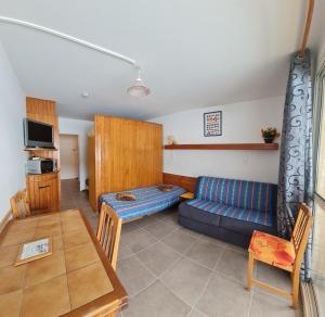 a living room with a couch and a table at Appt pied pistes et centre station Superdévoluy chez Locasoleil in Le Dévoluy