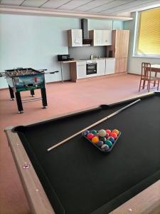 a pool table with a bowl of balls on it at Pension Eder in Bruck an der Leitha