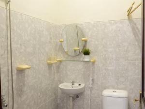 a bathroom with a sink and a mirror and a toilet at Singgah Tentrem Homestay - Yogyakarta in Salakan +19 photos