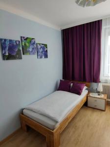 a bed in a room with a purple curtain at Pension Eder in Bruck an der Leitha