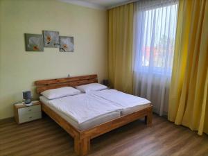 a bedroom with a bed and a large window at Pension Eder in Bruck an der Leitha
