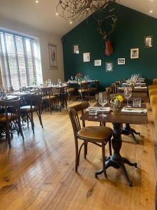 a dining room with tables and chairs and a green wall at The Kings Head Inn, Norwich - AA 5-Star rated in Norwich