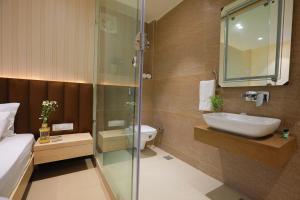 a bathroom with a shower and a sink and a toilet at Hotel Adora in New Delhi
