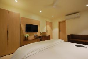 a hotel room with a bed and a flat screen tv at Hotel Adora in New Delhi