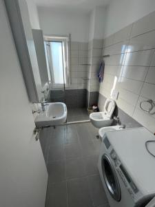 a bathroom with two sinks and a washing machine at Residence Lux Apartments at VALAMAR Hamallaj Gjiri Lalzit in Durrës