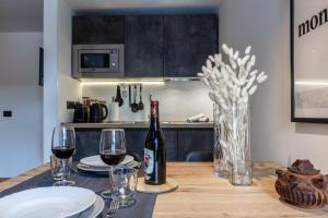a table with a bottle of wine and two glasses at HelloCHALET - Friends Ski House in Breuil-Cervinia +19 photos
