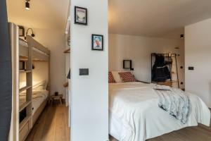 een slaapkamer met een bed en een stapelbed bij HelloChalet - Friends Ski House in Breuil-Cervinia