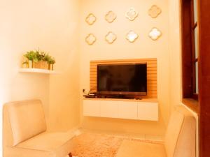 a living room with a television and a chair at Singgah Tentrem Homestay - Yogyakarta in Salakan