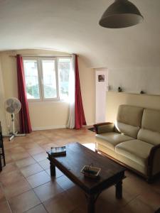 a living room with a couch and a coffee table at Studio Gite Mondragon (Vaucluse) in Mondragon