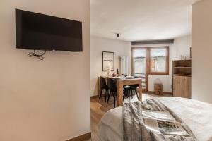 een slaapkamer met een bed en een tafel met stoelen bij HelloChalet - Friends Ski House in Breuil-Cervinia