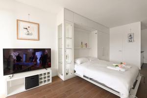 una camera con letto e TV a schermo piatto di View and Art - Happy Rentals a Castagnola