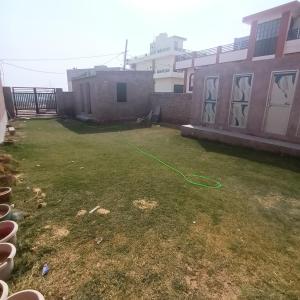 a yard with a green hose attached to a building at VTP Guest House in Bikaner