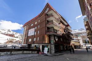 a building on a street with mountains in the background at HelloCHALET - Friends Ski House in Breuil-Cervinia