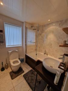 uma casa de banho com um WC, uma banheira e um lavatório. em Alton Rd guesthouse em Liverpool
