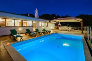 a swimming pool in front of a house at night at Villa Alte Springs by Algarve Vacation in Alte