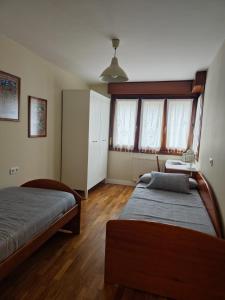 a bedroom with two beds and a table and windows at Zona centro con plaza de garaje VUT3983AS in Gijón