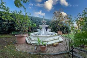 una fuente en medio de un jardín con plantas en GetTheKey Villa Cedro, en San Lazzaro di Savena
