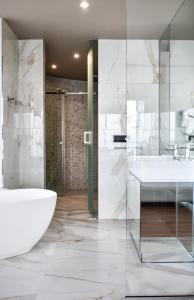 a bathroom with a tub and a sink and a shower at Yacht Hotel in Vlorë
