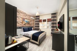 - une chambre avec un lit et un mur en briques dans l'établissement İstanbul Hotel & Suites, à Istanbul