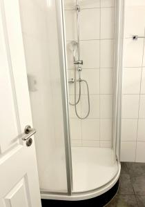 a shower with a glass door in a bathroom at Schöne Aussicht - b50247 in Hohegeiß