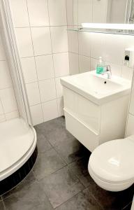a white bathroom with a toilet and a sink at Schöne Aussicht - b50247 in Hohegeiß
