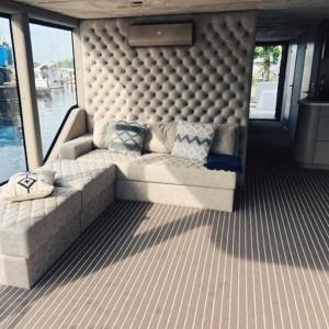 un sofá sentado en la parte trasera de un barco en Luxus Hausboot mit Jacuzzi, en Kolonie Zern