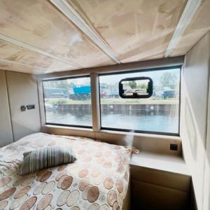 Habitación pequeña con cama y ventana en Luxus Hausboot mit Jacuzzi, en Kolonie Zern