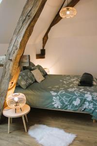 a bedroom with a bed and a table at gîte les Blés Dorés in Corgengoux