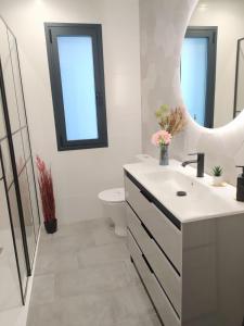 a bathroom with a sink and a toilet and a mirror at El susurro del tajo. El rio in Toledo