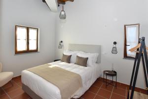 een slaapkamer met een groot bed en een statief bij Turismo Rural Pedremoura in Vila Ruiva