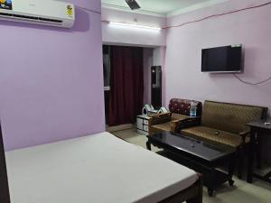 ChopanにあるHotel Sarvapriyaのベッド、ソファ、テレビが備わる客室です。
