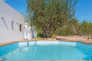 ein Pool vor einem Haus mit einem Baum in der Unterkunft Villa Sa Planeta in San Jose de sa Talaia