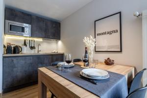 a dining room with a table and a kitchen at HelloCHALET - Friends Ski House in Breuil-Cervinia