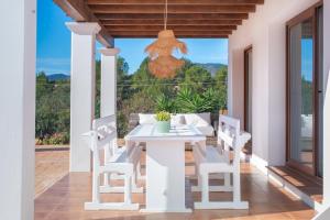 eine Terrasse mit einem weißen Tisch und Stühlen auf einer Veranda in der Unterkunft Villa Sa Planeta in San Jose de sa Talaia