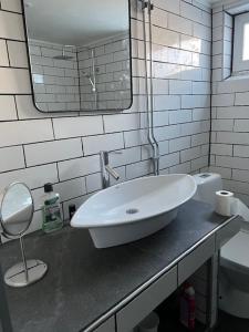 uma casa de banho branca com um lavatório e um espelho em Hedén Apartment em Kållered