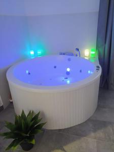 bañera blanca en una habitación con luz azul en El susurro del tajo. El rio en Toledo