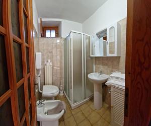łazienka z prysznicem, dwiema umywalkami i toaletą w obiekcie A casa di Giò w Aoście