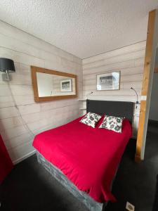 - une chambre avec un lit rouge et 2 oreillers dans l'établissement Andro, à Chamonix-Mont-Blanc