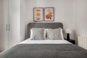 een slaapkamer met een bed met twee foto's aan de muur bij Blueground Les Corts balcony nr Camp Nou BCN-82 in Barcelona