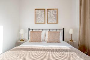 a white bedroom with a bed with two lamps at Blueground Dreta de lEixample nr pl catalunya BCN-48 in Barcelona