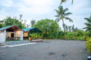 Kondivli的住宿－White Sand Beach Resort，棕榈树和车道的房子
