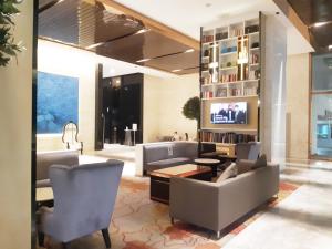a living room with a couch and chairs and a tv at KLCC Suites at Platinum in Kuala Lumpur