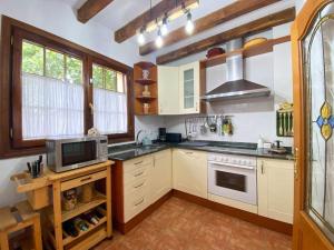 a kitchen with white cabinets and a microwave at Casa Chuchi in Ampuero